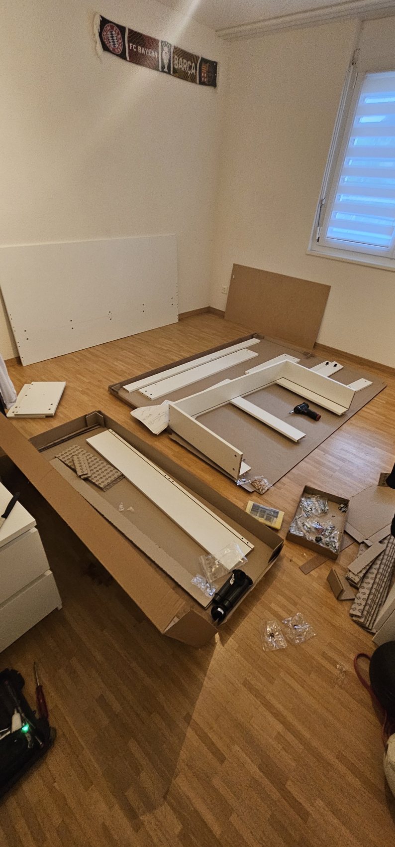 Möbelteile und Verpackung ausgelegt für eine Montage auf Parkett